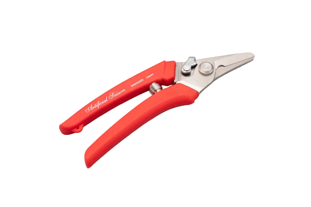 Red-handled pruning shears on a gray background. Craft shears for cutting wires and artificial flowers